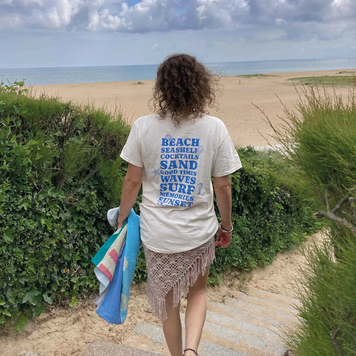 Jeune femme de dos face à la mer